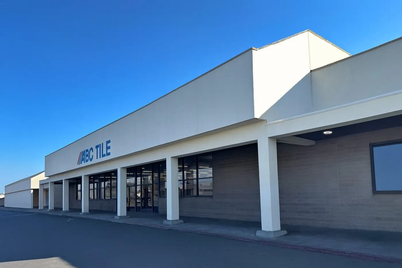 Commercial building with ARCO Tile sign under a clear blue sky