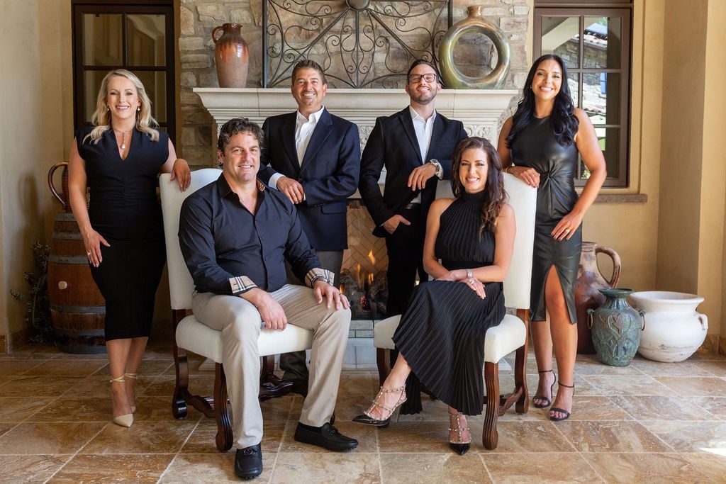 Group of six real estate agents posing in a living room